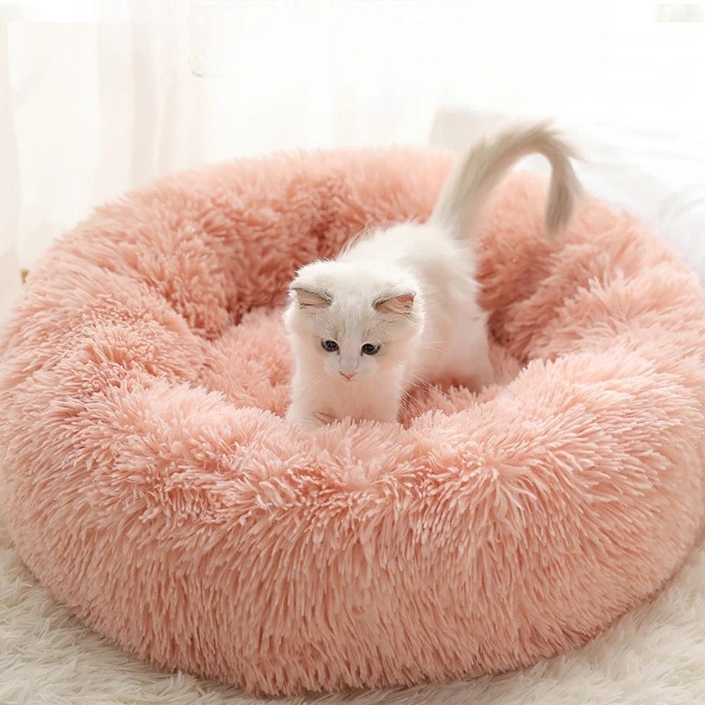 Coussin rond en peluche rose, doux et moelleux, idéal pour un chat dans un intérieur cosy