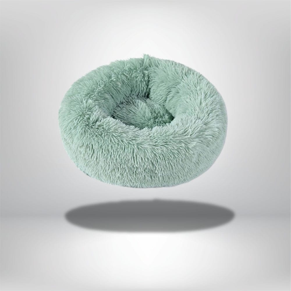 Coussin rond en fausse fourrure vert menthe, idéal pour le confort des chats dans un salon moderne