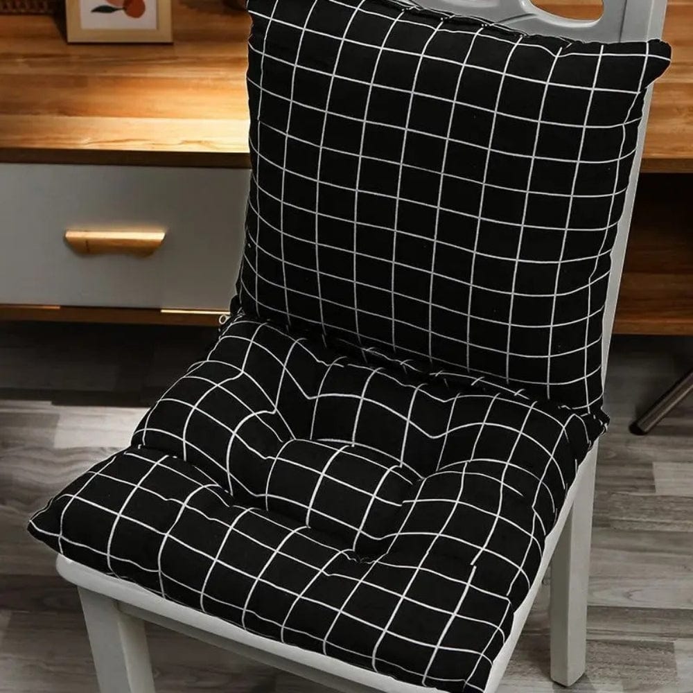 Coussin de chaise noir à motifs carreaux blancs, posé sur une chaise dans un salon moderne