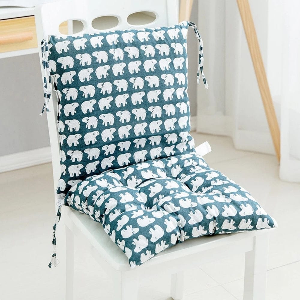 Coussin de chaise en coton bleu avec motifs d'éléphants blancs, placé sur une chaise dans un intérieur lumineux