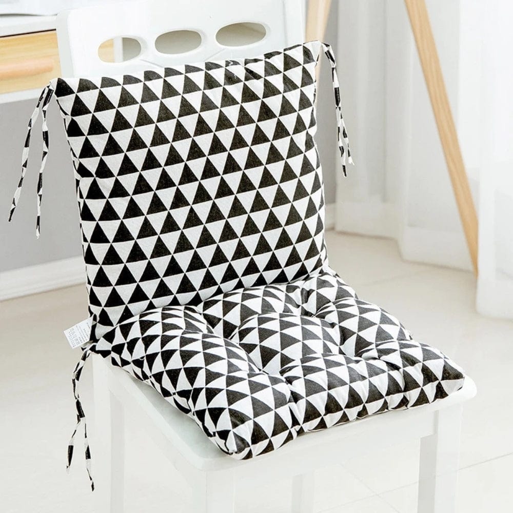 Coussin de chaise en tissu noir et blanc avec motif géométrique en triangles, posé sur une chaise blanche