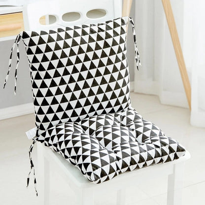 Coussin de chaise en tissu noir et blanc avec motif géométrique en triangles, posé sur une chaise blanche