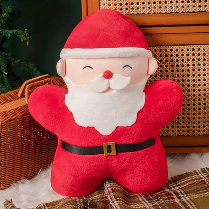 Coussin décoratif en forme de père Noël, rouge et blanc, posé sur un plaid dans un salon chaleureux