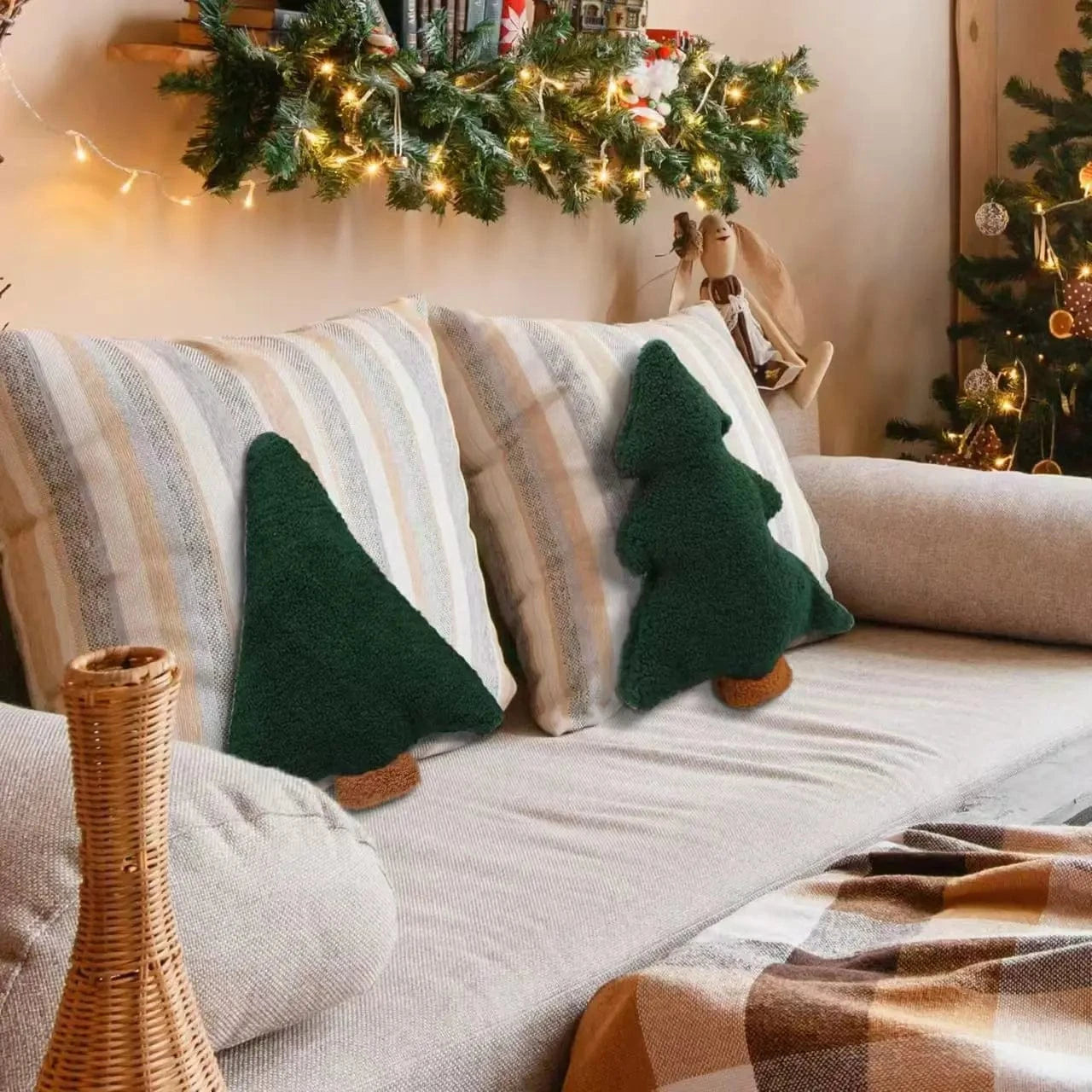 Coussins décoratifs en forme de sapin, verts et doux, sur un canapé beige avec des rayures