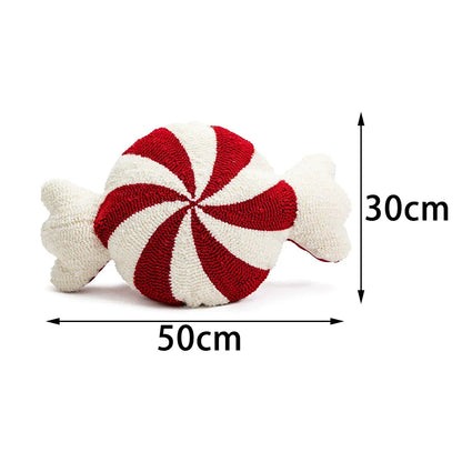 Coussin décoratif en forme de bonbon avec des rayures rouges et blanches, posé sur un canapé