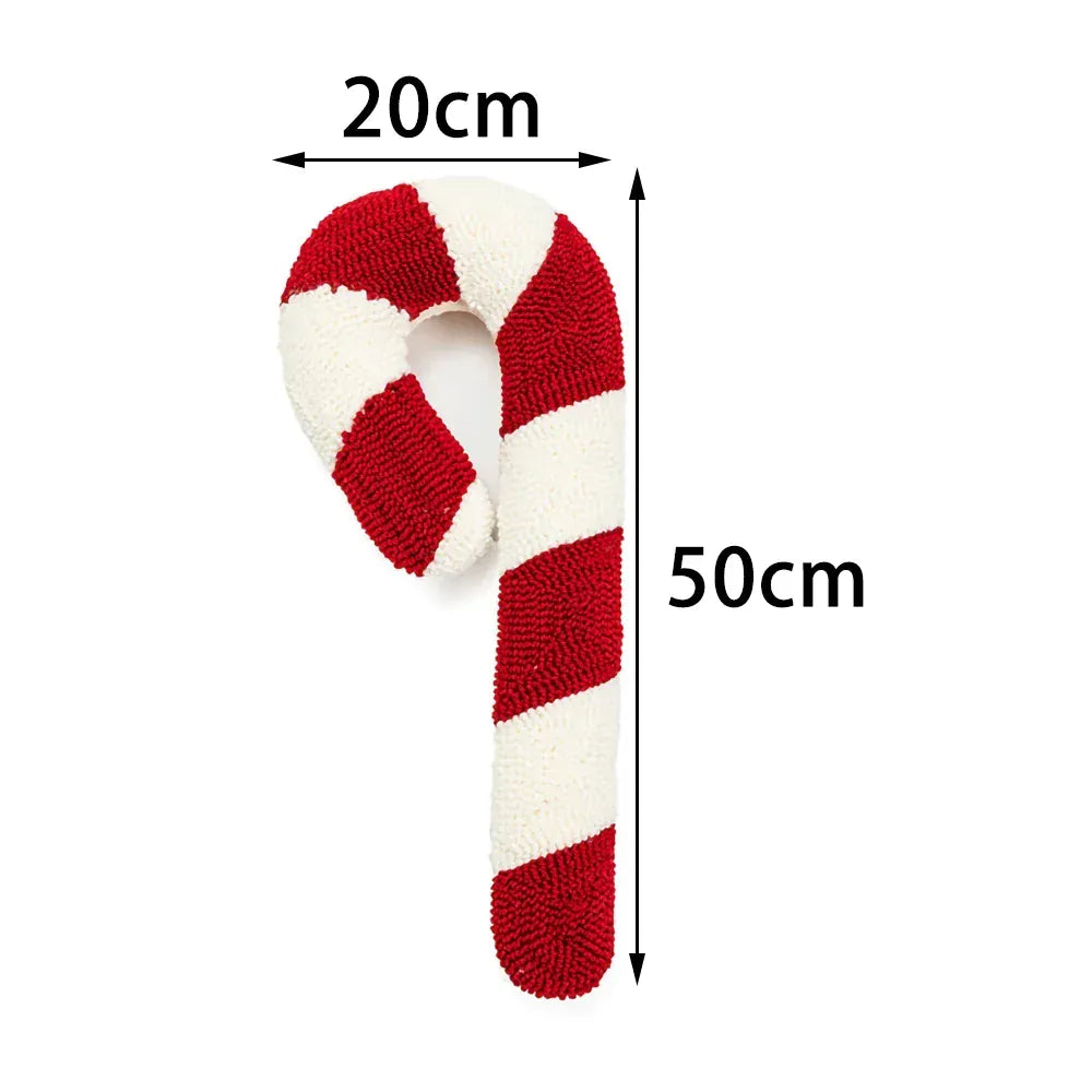Coussin décoratif en forme de sucre d'orge, rouge et blanc, posé sur un canapé moderne