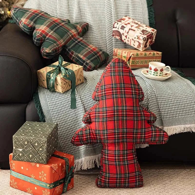 Coussins décoratifs en tartan rouge et vert sur un canapé, créant une ambiance cocooning et festive