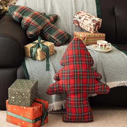 Coussins décoratifs en tartan rouge et vert sur un canapé, créant une ambiance cocooning et festive