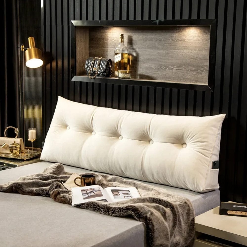 Coussin déco géant en velours beige avec des boutons, posé sur un lit moderne et élégant