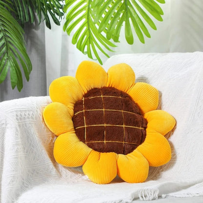 Coussin décoratif en forme de tournesol jaune avec un centre marron, posé sur un canapé blanc