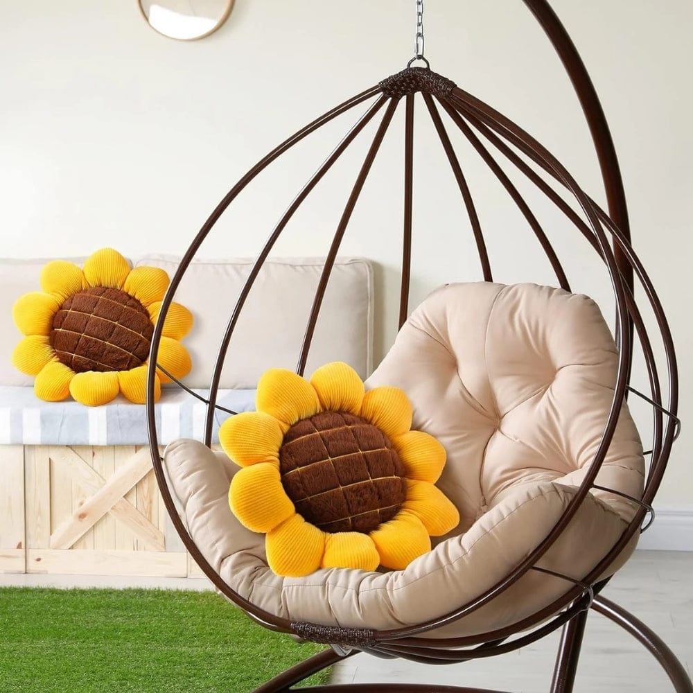Coussin déco en forme de tournesol, jaune et marron, posé sur un fauteuil suspendu dans un salon moderne
