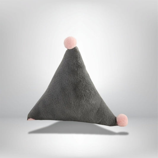 Coussin décoratif en forme de triangle gris avec pompons roses, posé sur un fond neutre