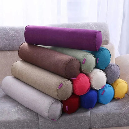 Coussins boudins colorés en tissu, empilés sur un canapé, ajoutant une touche décorative au salon