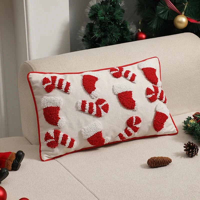 Housse de coussin décoratif avec motifs de bonnets de Noël rouges et blancs sur un canapé beige