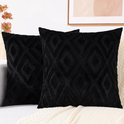 Coussins décoratifs en velours noir avec motifs géométriques, posés sur un canapé clair dans un salon élégant