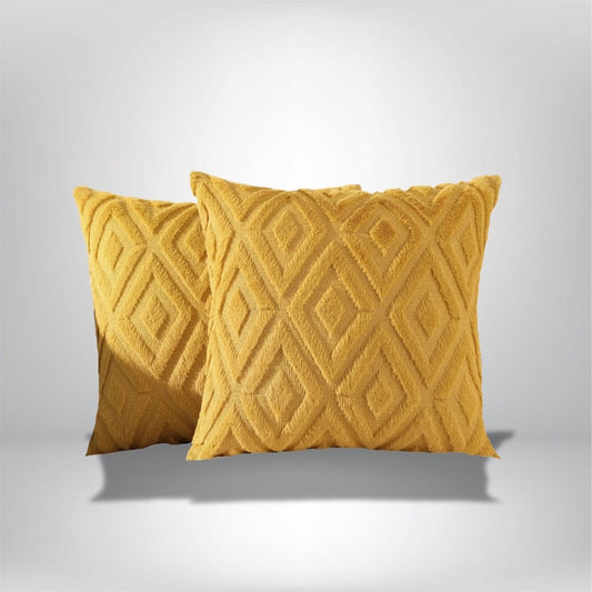 Deux coussins décoratifs en velours jaune avec un motif géométrique, posés sur un fond neutre