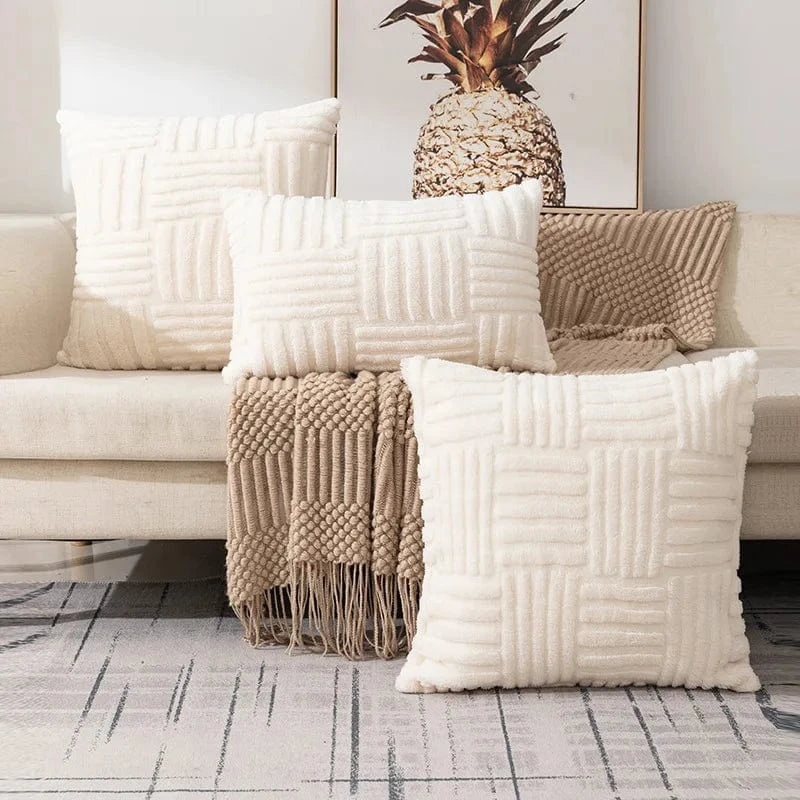 Coussins décoratifs en fausse fourrure crème sur un canapé, créant une ambiance cocooning et raffinée