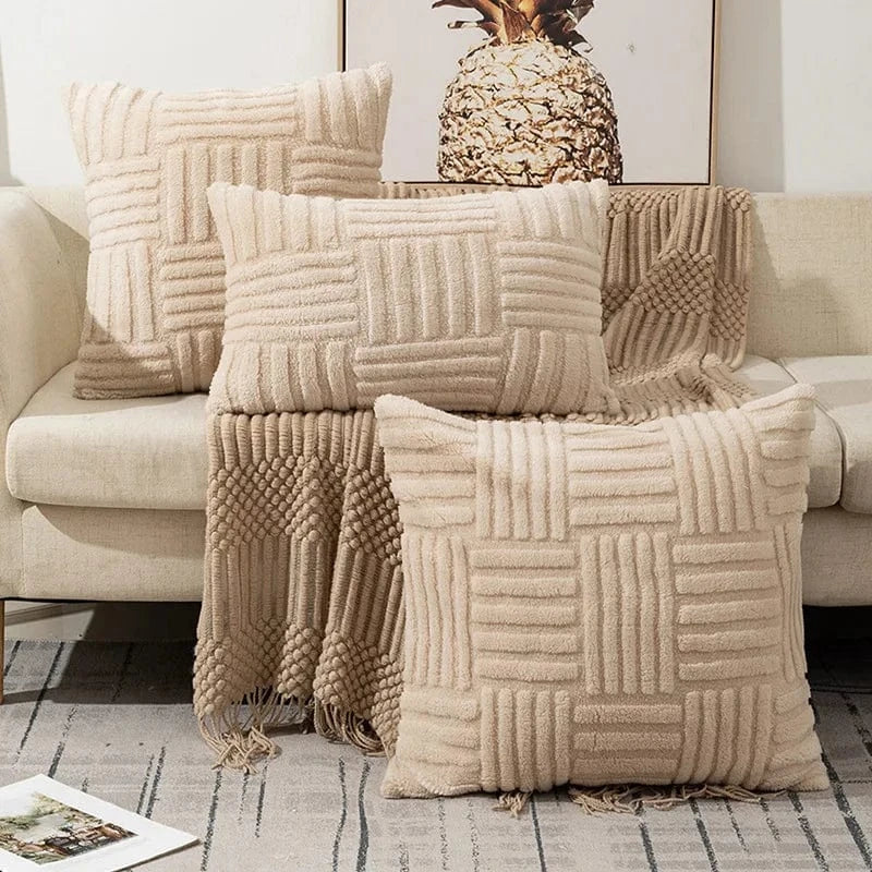 Coussins décoratifs en fausse fourrure crème, disposés sur un canapé, créant une ambiance cocooning et raffinée