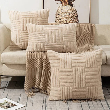 Coussins décoratifs en fausse fourrure crème, disposés sur un canapé, créant une ambiance cocooning et raffinée