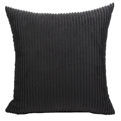 Coussin déco en velours côtelé noir, au design intemporel, posé sur un canapé moderne