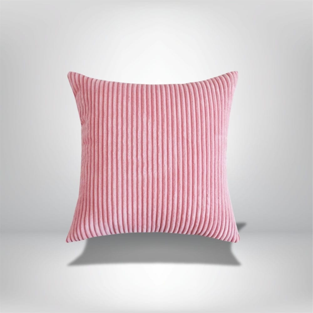 Coussin décoratif en velours côtelé rose, avec des rayures, posé sur un fond neutre, idéal pour un canapé élégant