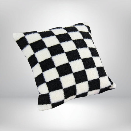 Housse de coussin à carreaux noir et blanc, texture douce, posée sur un fond neutre