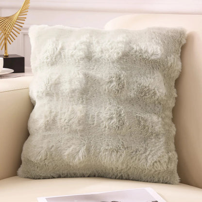 Coussin déco en fausse fourrure douce, couleur vert pâle, posé sur un canapé moderne dans un intérieur cocooning