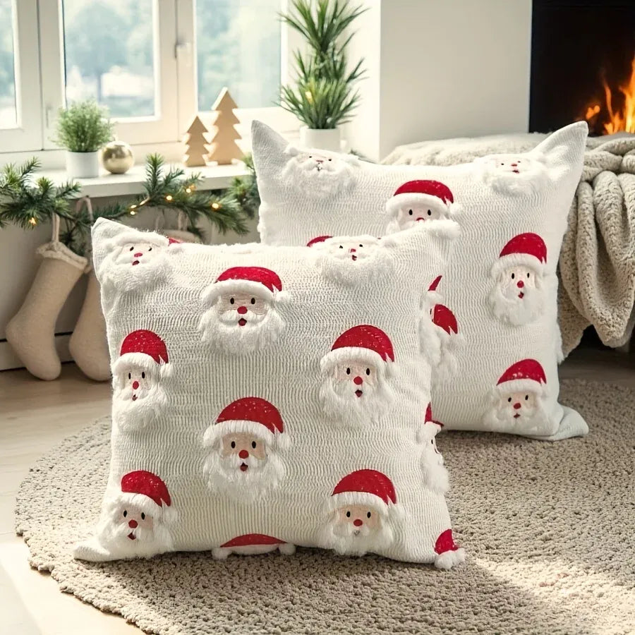 Housse de coussin décorative blanche avec motifs de Père Noël, posée sur un tapis dans un salon chaleureux