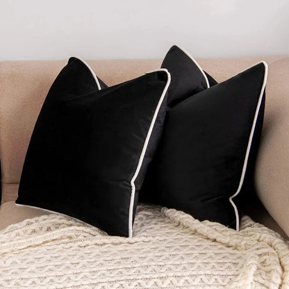 Coussins noirs élégants avec bordure blanche sur un canapé beige, ajoutant une touche de sophistication à votre décoration intérieure