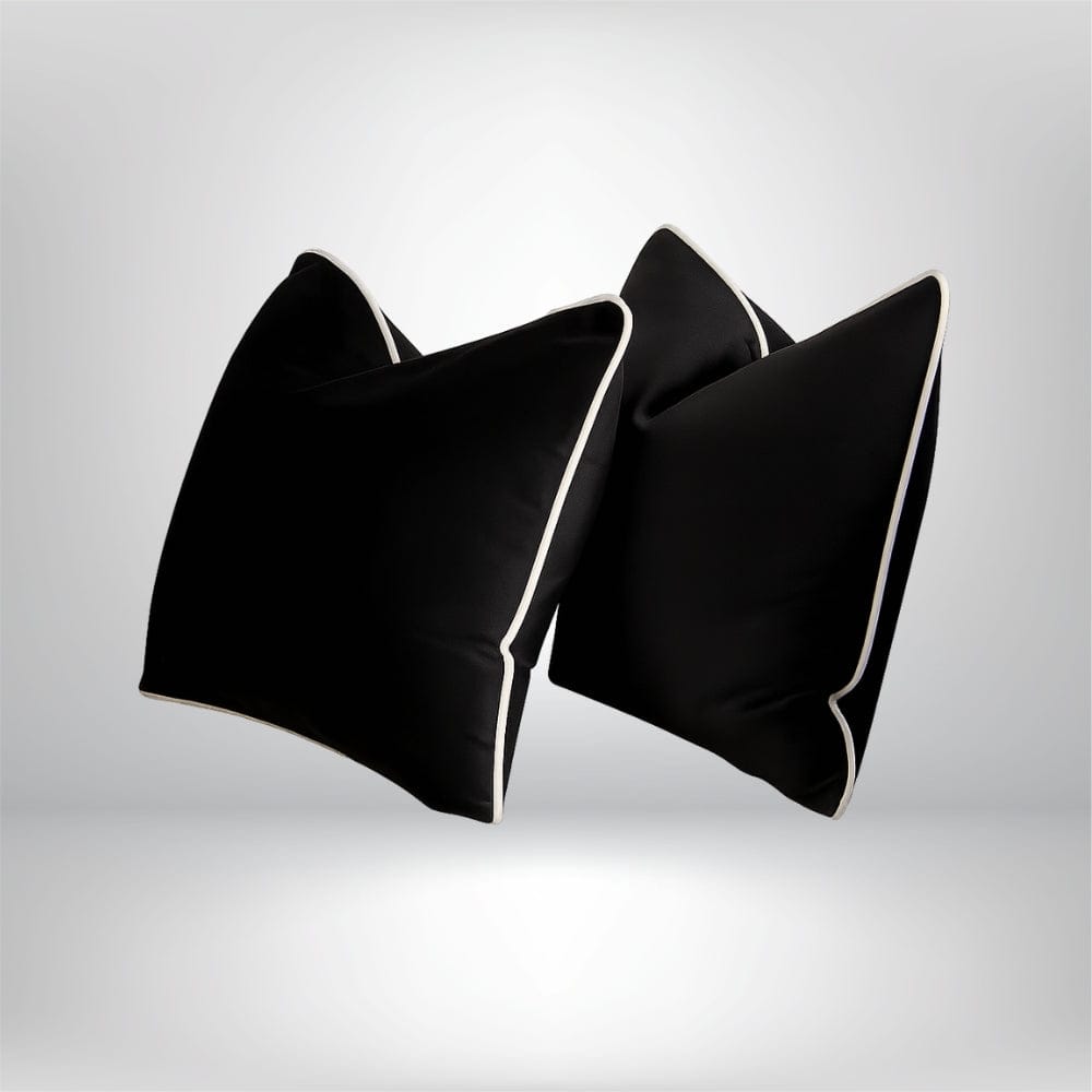 Coussins décoratifs noirs avec bordure blanche, posés sur un fond neutre, apportant une touche élégante à votre intérieur