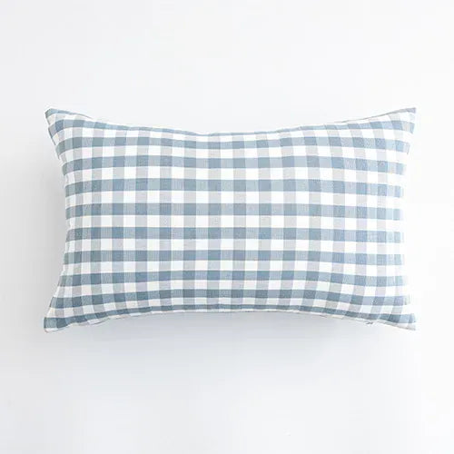 Housse de coussin rectangulaire à carreaux bleus et blancs, posée sur un fond neutre