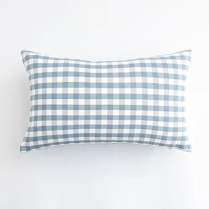 Housse de coussin rectangulaire à carreaux bleus et blancs, posée sur un fond neutre