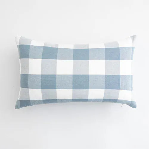 Housse de coussin rectangulaire à motifs carreaux bleu ciel et blanc, posée sur un fond neutre