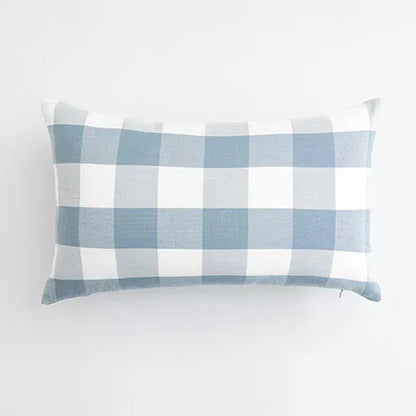 Housse de coussin rectangulaire à motifs carreaux bleu ciel et blanc, posée sur un fond neutre