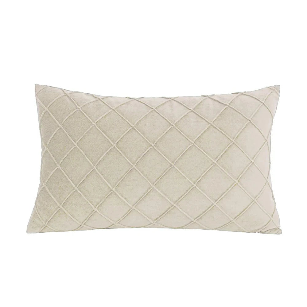 Coussin déco rectangulaire en velours beige avec motif matelassé, posé sur un canapé moderne