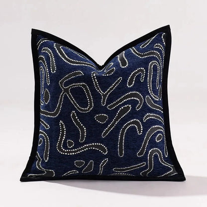 Coussin décoratif bleu marine avec motifs abstraits blancs, idéal pour un canapé moderne ou un salon élégant