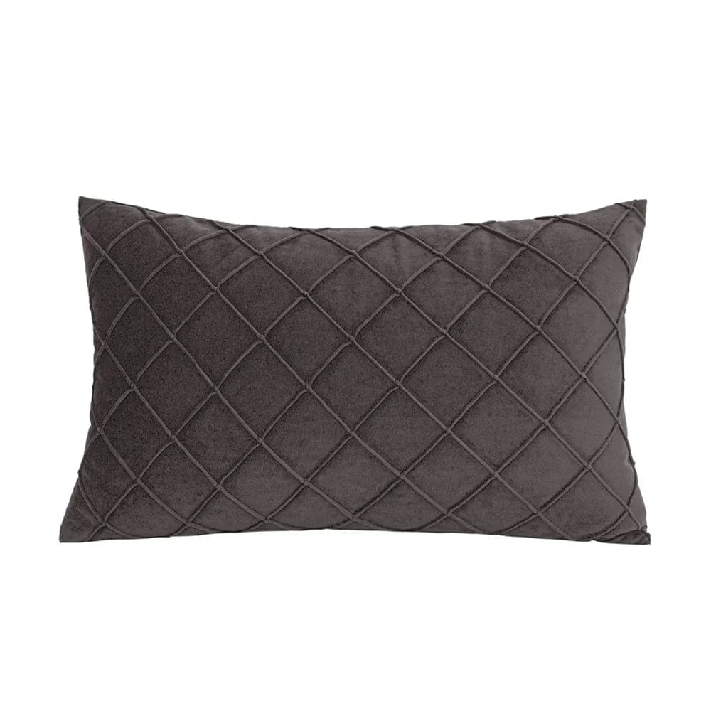 Coussin déco rectangulaire en velours gris, motif losanges, posé sur un canapé moderne