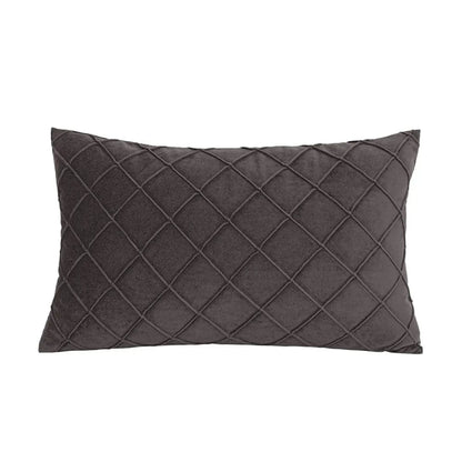 Coussin déco rectangulaire en velours gris, motif losanges, posé sur un canapé moderne