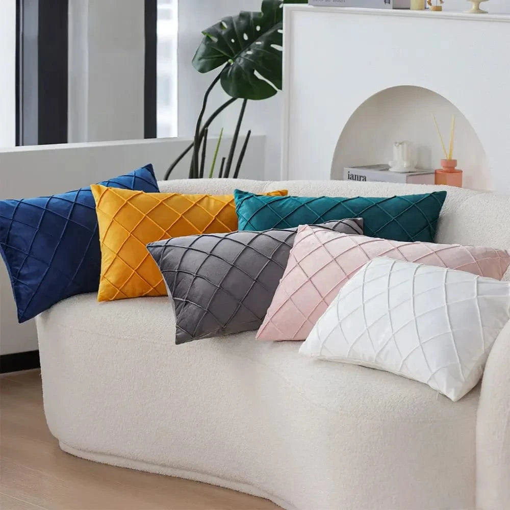 Coussins décoratifs aux couleurs vives, en velours, disposés sur un canapé moderne et cosy