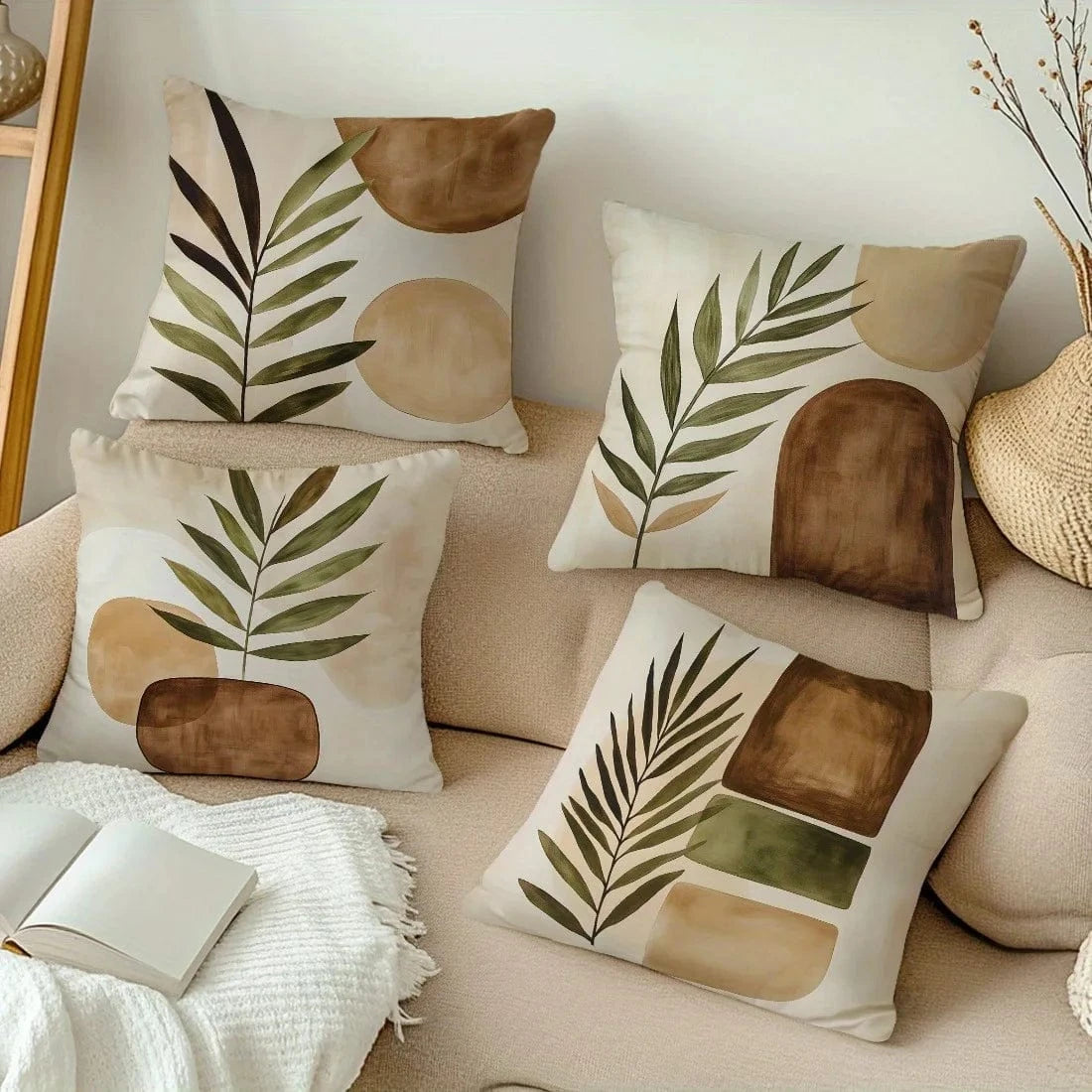 Quatre coussins décoratifs aux motifs géométriques dans des tons naturels, posés sur un canapé beige