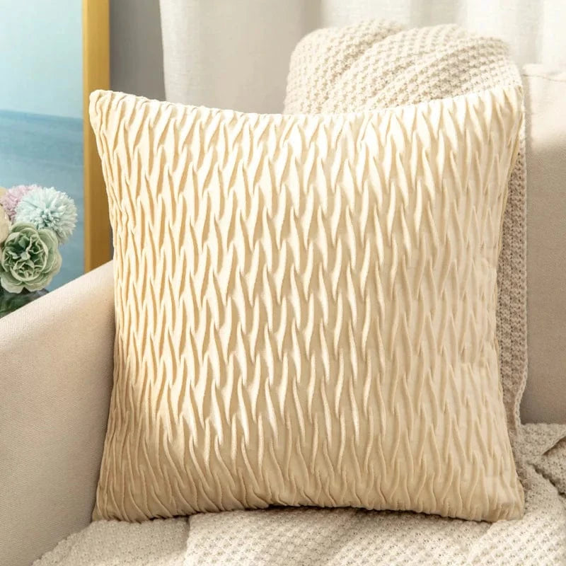 Coussin décoratif en velours beige avec un motif ondulé, posé sur un canapé élégant dans un salon moderne