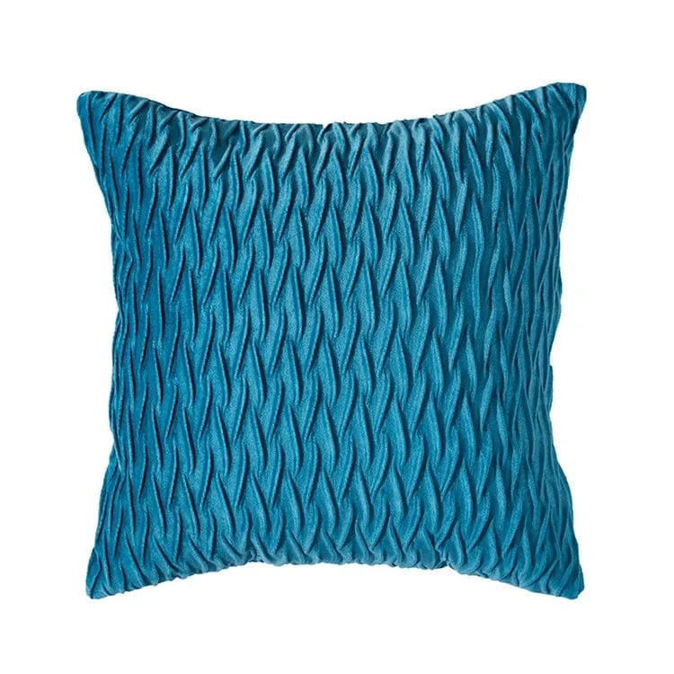 Coussin décoratif en velours bleu avec un motif texturé, parfait pour un canapé moderne et élégant