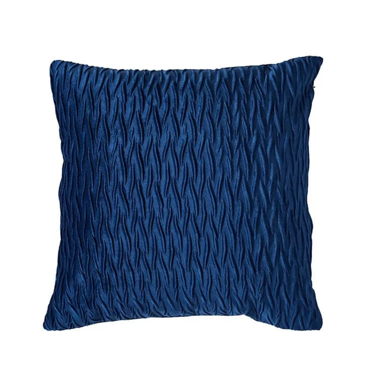 Coussin décoratif en velours bleu nuit avec un motif texturé, posé sur un canapé moderne