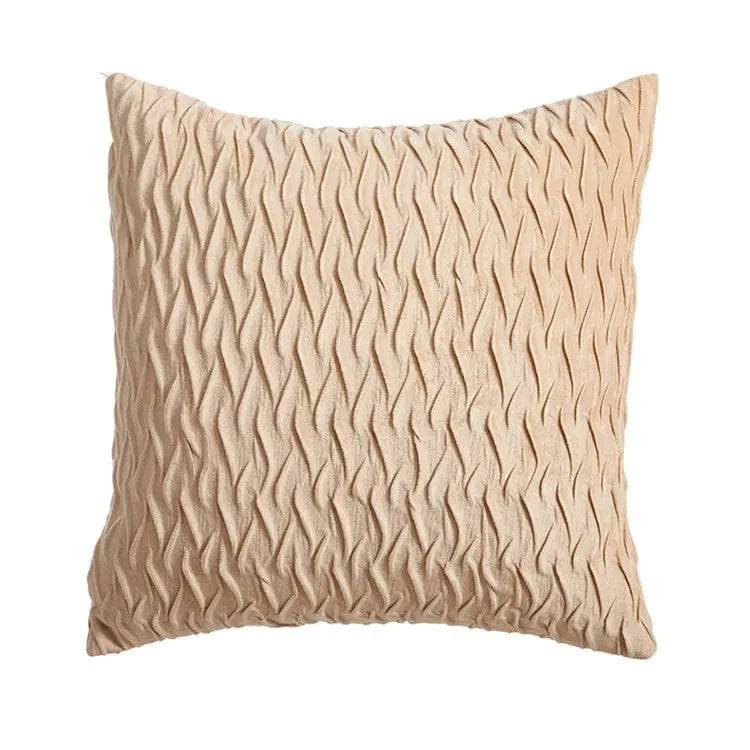 Coussin décoratif en velours beige avec un motif ondulé, posé sur un canapé moderne
