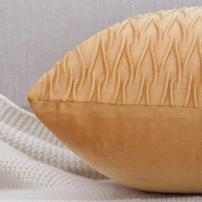 Coussin décoratif en velours beige avec un motif texturé, posé sur un canapé moderne et élégant