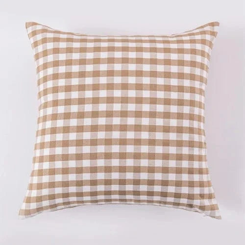 Coussin déco à carreaux beige et blanc, parfait pour un fauteuil dans un salon élégant