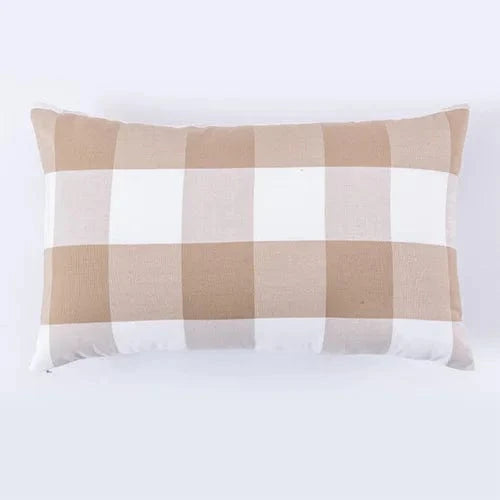Coussin décoratif rectangulaire aux motifs à carreaux beige et blanc, posé sur un fond neutre