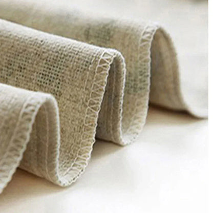 Housse de coussin décoratif en lin beige, légèrement texturé, posée sur une surface claire