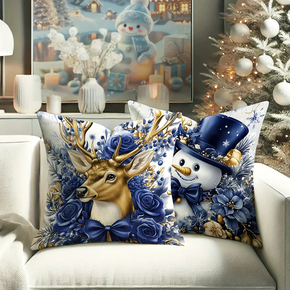 Coussins décoratifs aux motifs de renne et bonhomme de neige, sur un canapé blanc, avec des fleurs bleues et dorées