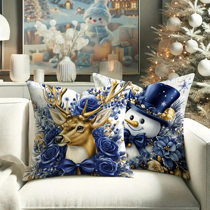Coussins décoratifs aux motifs de renne et bonhomme de neige, sur un canapé blanc, avec des fleurs bleues et dorées